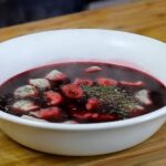 Czerwony barszcz z uszkami w białej misce, screen z YouTube